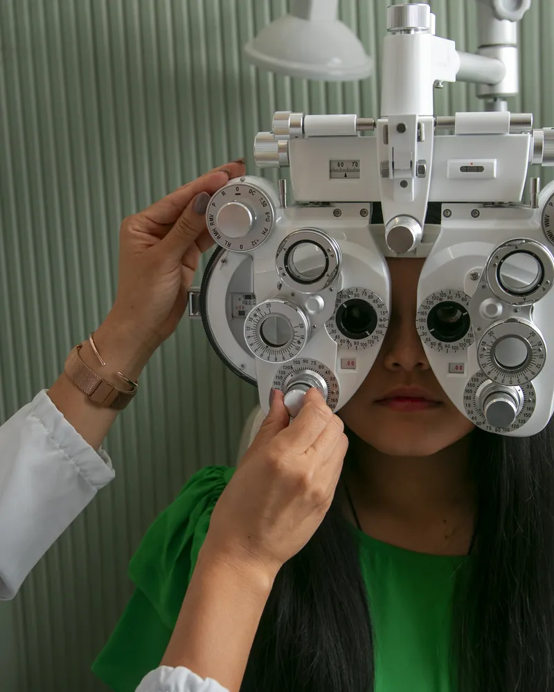 Exame de vista no refrator, ajustado diante dos olhos da paciente